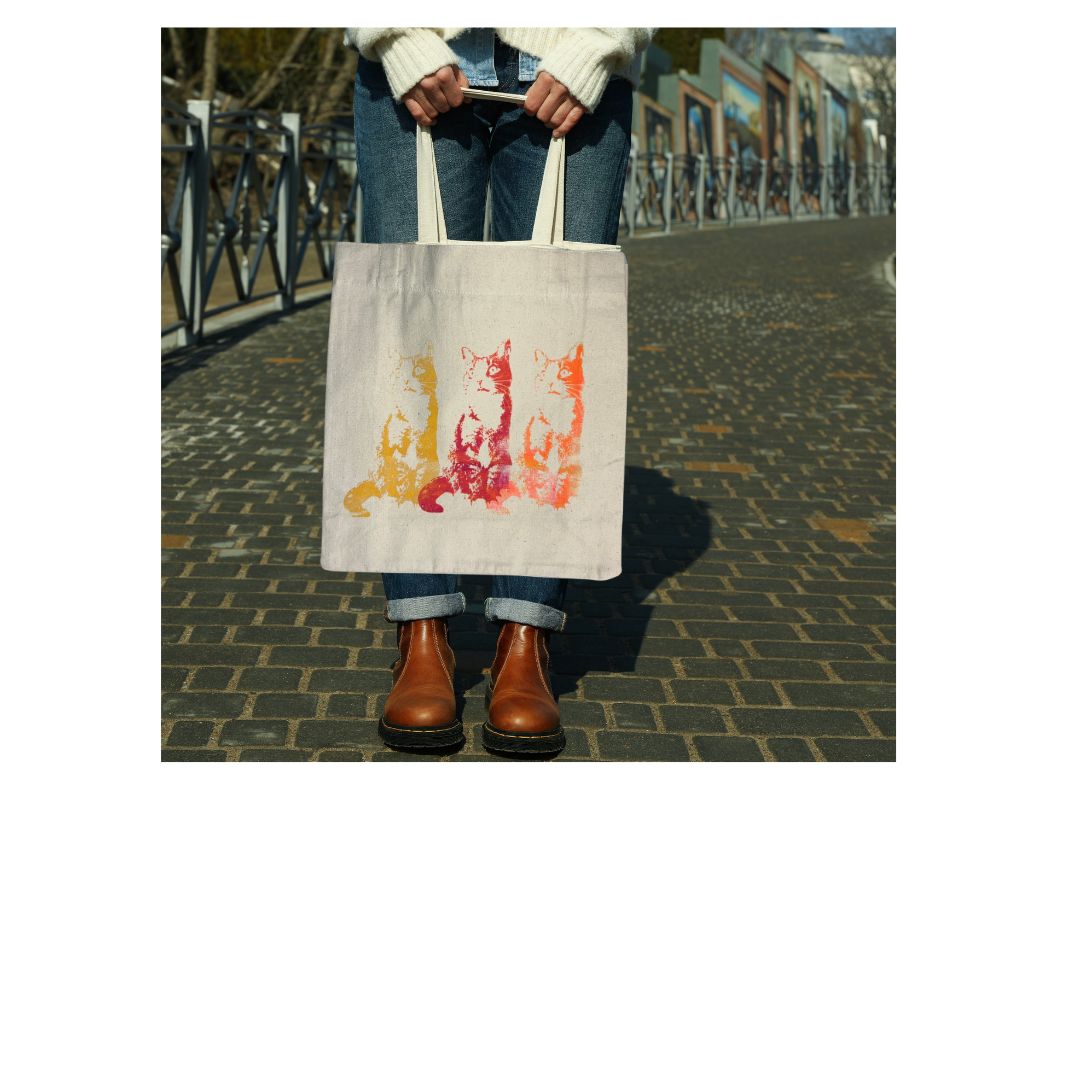 Person holding a tote bag with cat design on a street