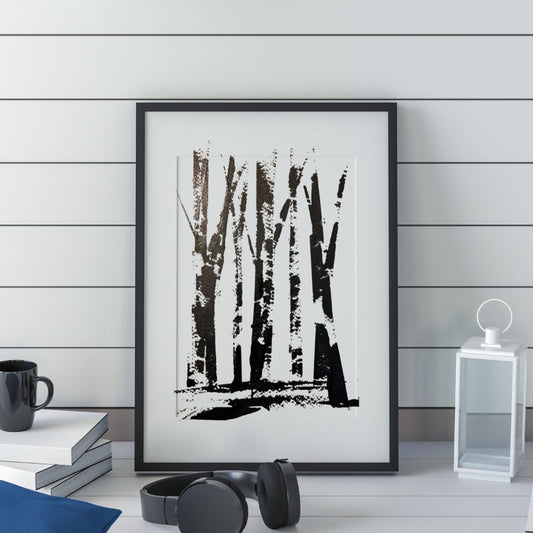Framed black and white abstract art print on a wooden wall with books and a cup.