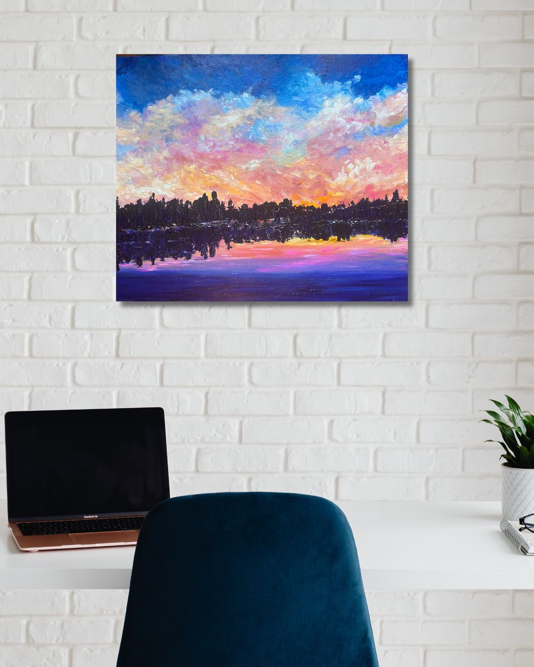Original landscape painting by Ottawa artist Mireille Laroche on a white brick wall above a desk and chair