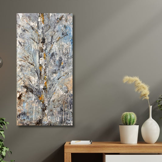 a textured abstract birch tree painting with cool greys and warm accents by Ottawa artist Mireille Laroche placed  on a wall with a wooden table and decorative items below.