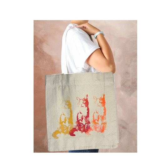 Tote bag with cat design held by a person against a neutral background