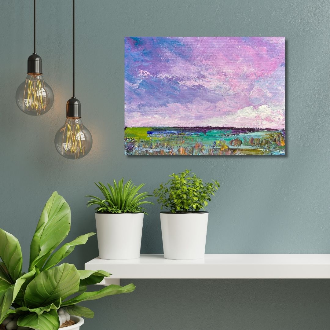 Painting of an abstract  landscape with a purple sky  by Ottawa artist Mireille Laroche  on a wall above a white shelf with potted plants.