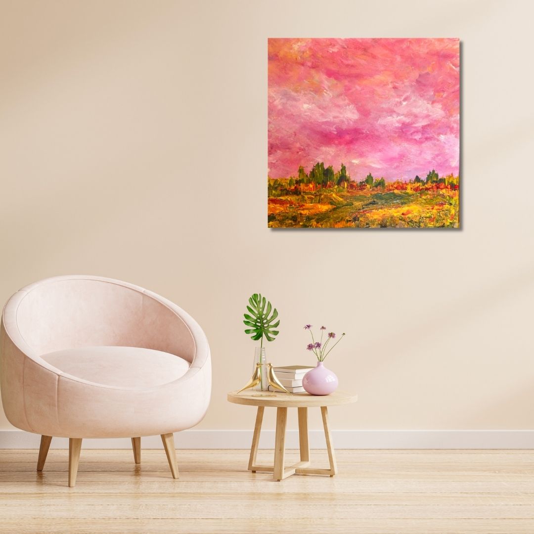 Abstract landscape painting by Ottawa artist Mireille Laroche on a wall above a light pink chair and small wooden table with decorative items.