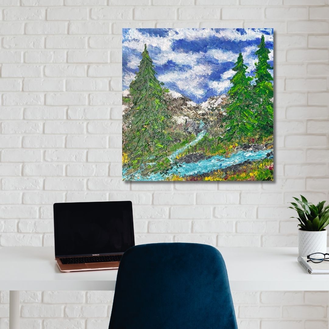 Painting of a mountain landscape with trees and a river by Ottawa artist Mireille Laroche hanging on a white brick wall above a desk.