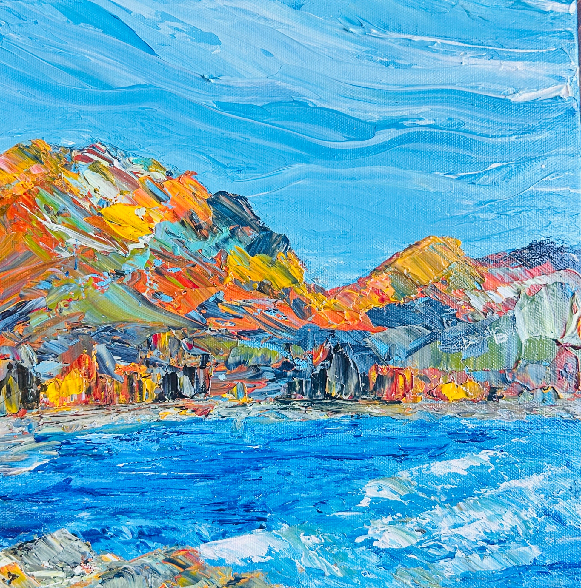 An abstract landscape painting of mountains and water in vibrant blue, orange, yellow, and green tones, by Ottawa artist Mireille Laroche