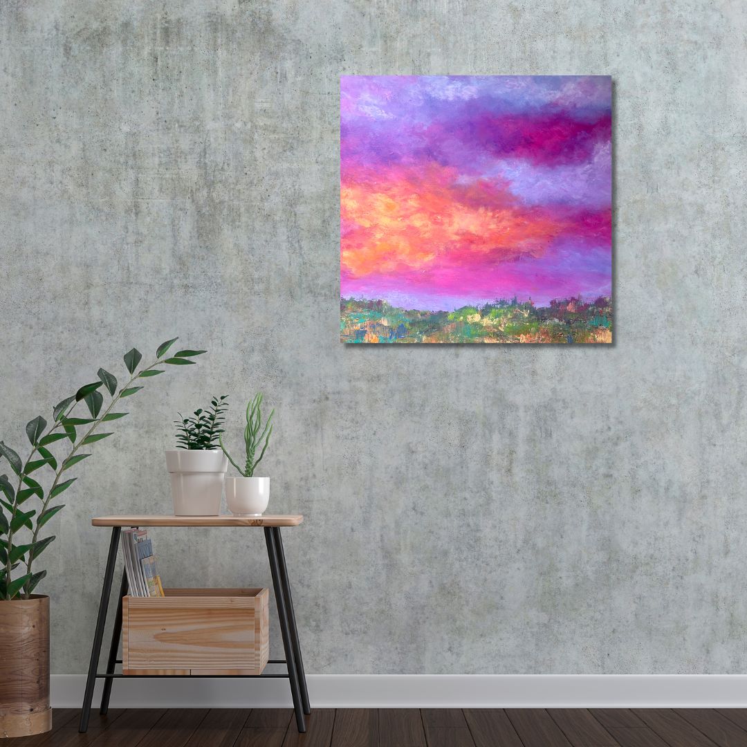 Colorful abstract painting of a sky with pink, purple, and orange hues by Ottawa artist Mireille Laroche on a textured wall above a wooden side table with plants.