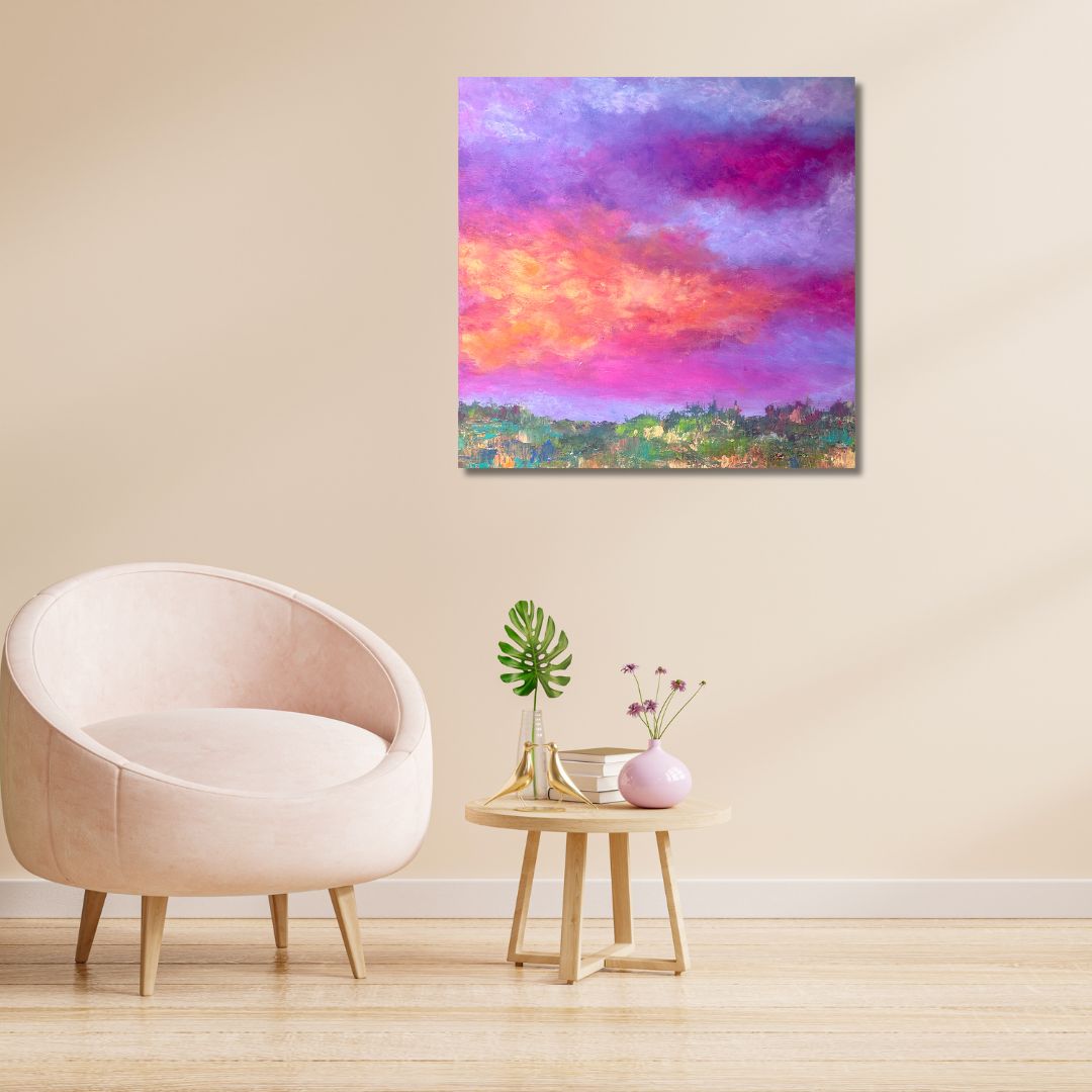 Colorful abstract painting of a sky with pink, purple, and orange hues by Ottawa artist Mireille Laroche on a wall above a light-colored chair and small table with decorative items.