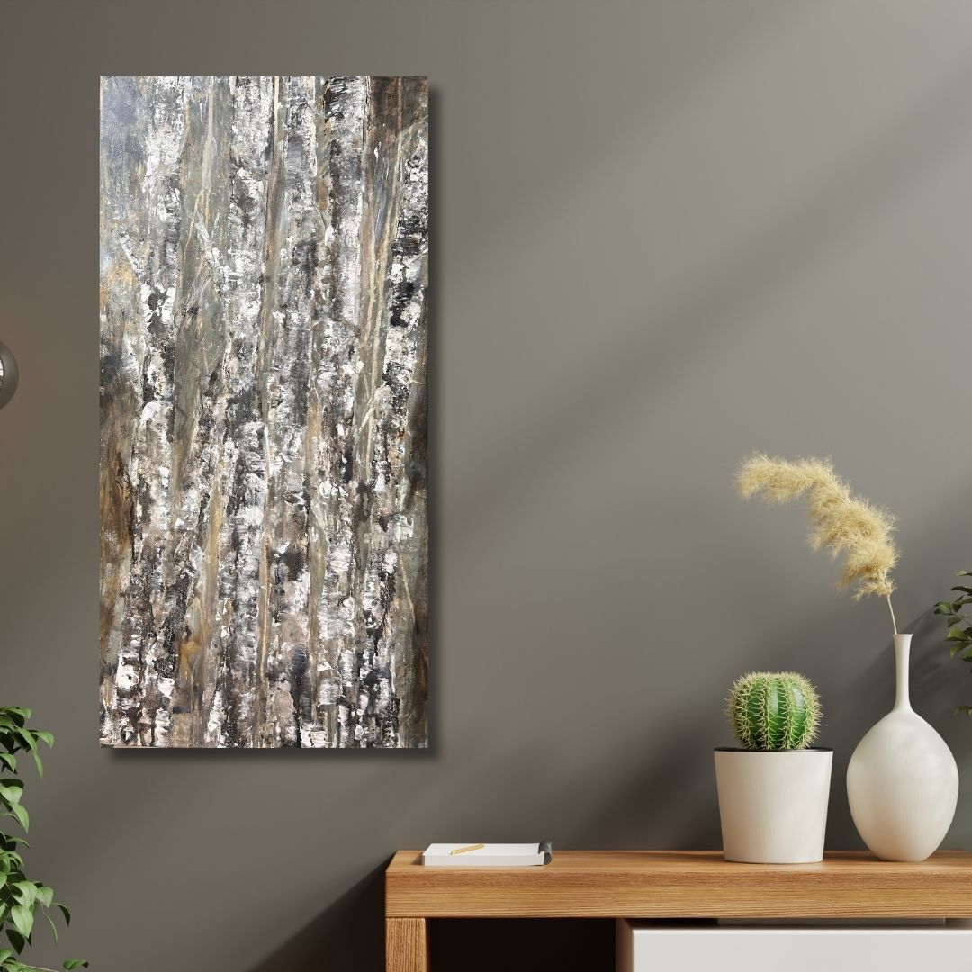 Abstract painting of birch trees in earthy tones by Ottawa artist Mireille Laroche placed on a wall with a wooden table and decorative items below.