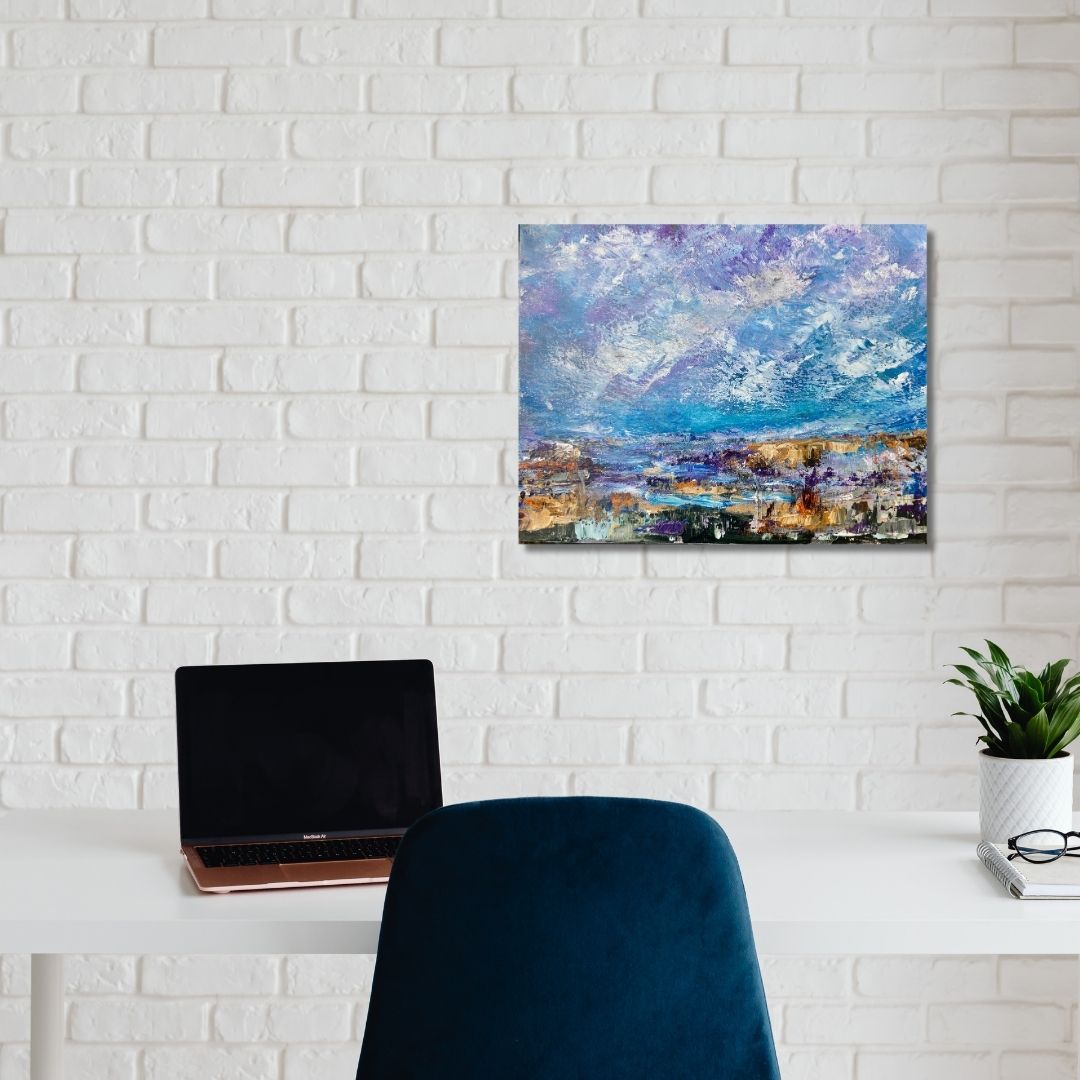 Abstract landscape painting by Ottawa artist Mireille Laroche  of a mountain landscape on a white brick wall above a desk with a laptop and chair.
