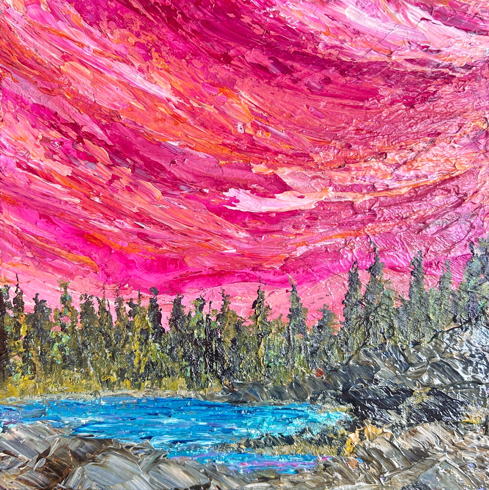 Impressionistic landscape painting featuring a vibrant magenta and pink sky, a dark green pine forest, a bright blue lake, and textured gray-brown rocks in the foreground by Ottawa artist Mireille Laroche