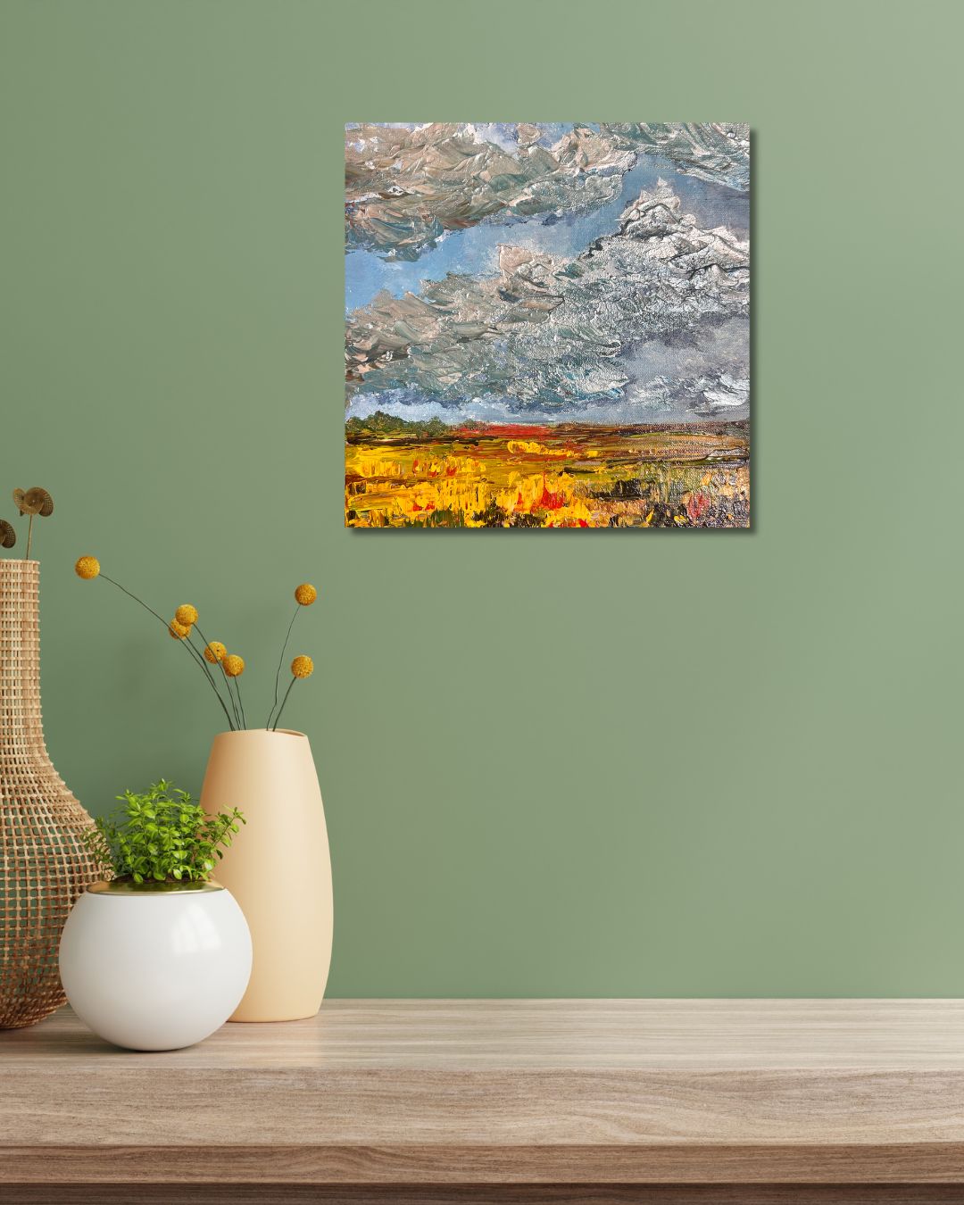 Semi-abstract acrylic by Ottawa artist Mireille Laroche depicting silver clouds over the Prairies.  Painting is on a green wall above a shelf with decorative pots on the left