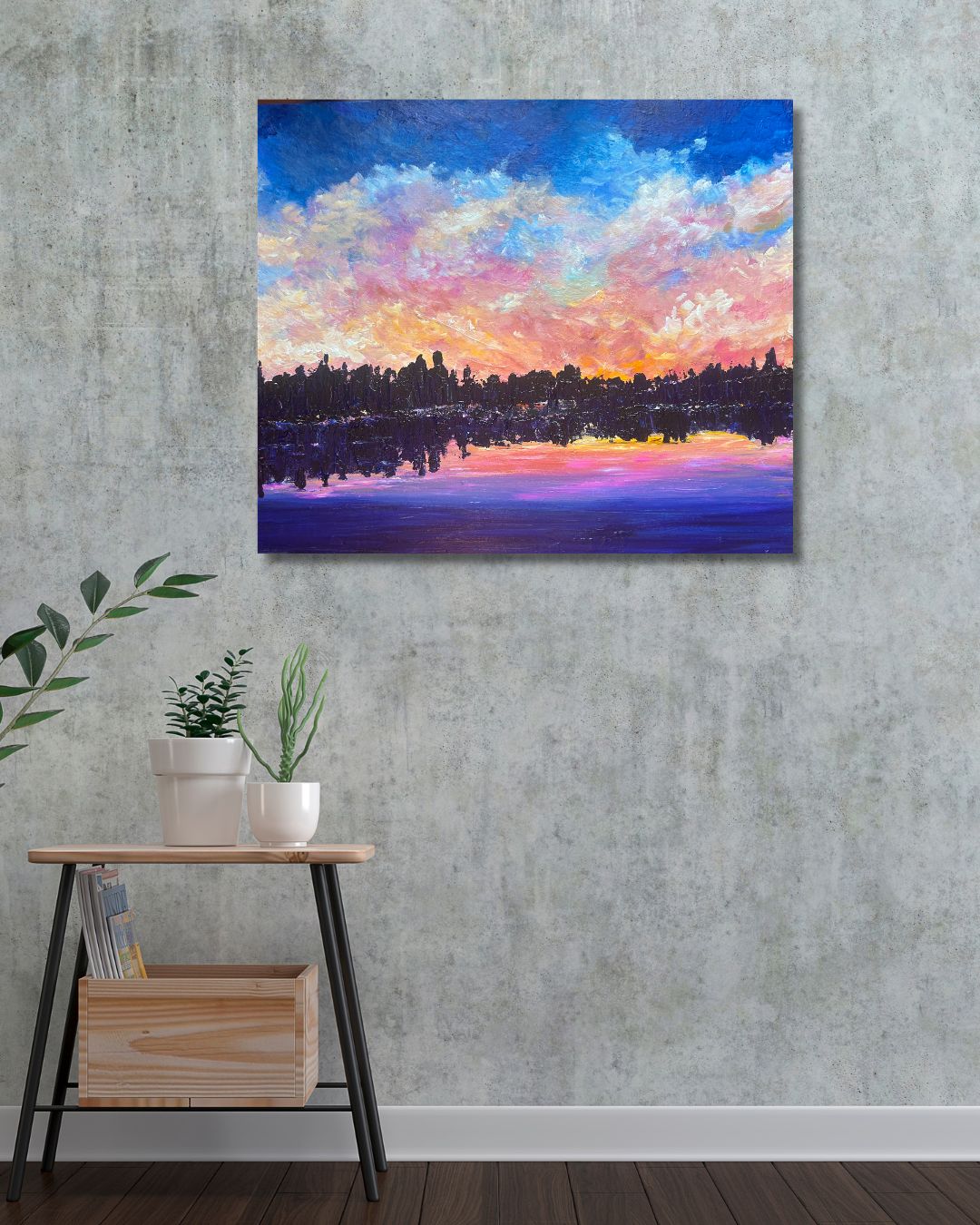 Original landscape painting by Ottawa artist Mireille Laroche on a wall above stool and plants