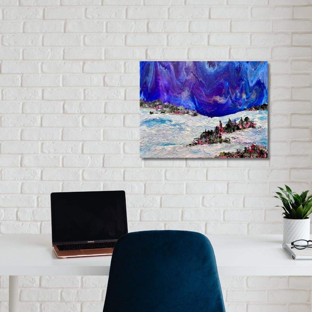 Colorful abstract painting depicting a wintery scene by Ottawa artist Mireille Laroche on a white brick wall above a desk with a laptop and chair.