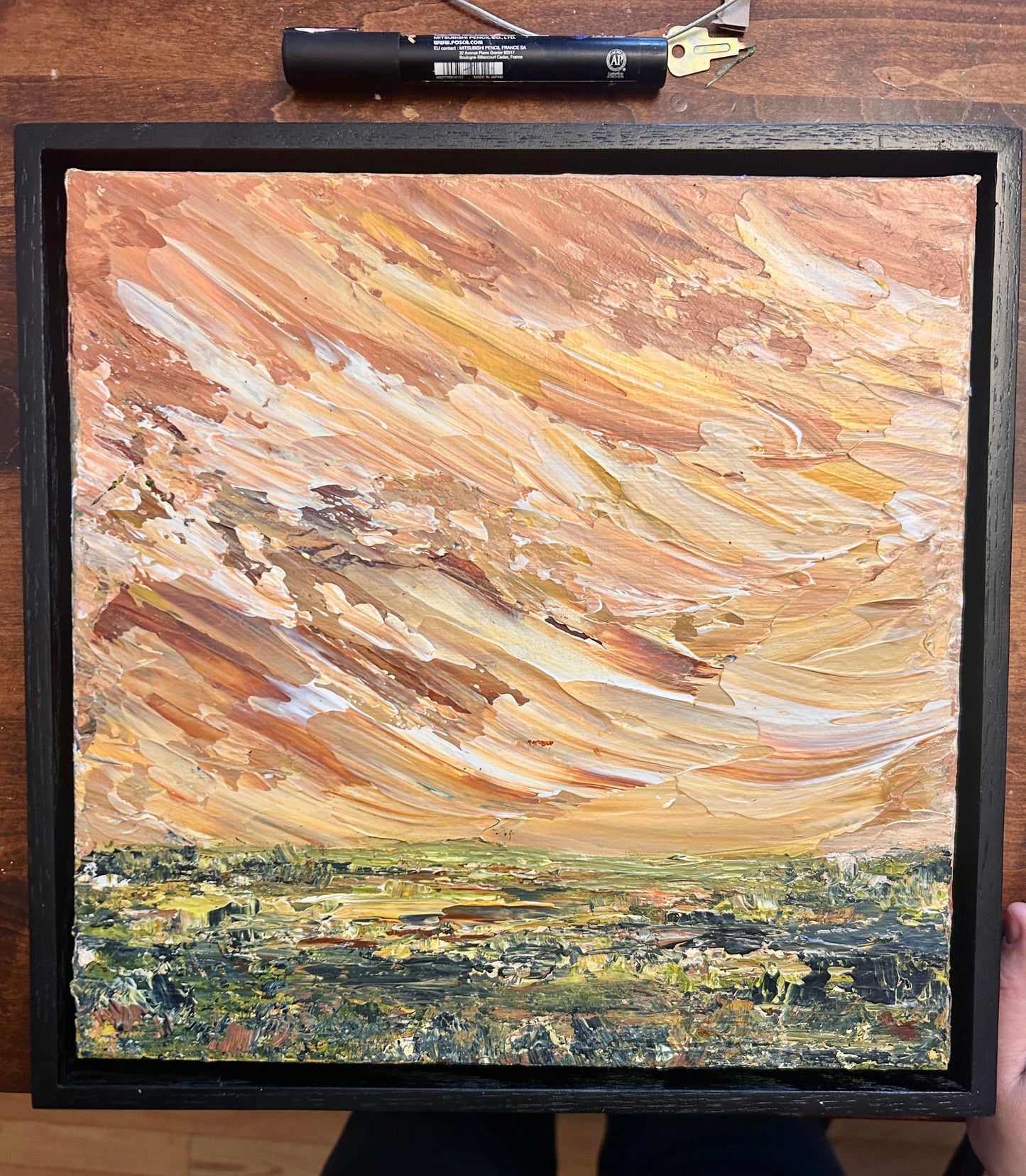 Framed abstract landscape painting with floating frame by Ottawa artist Mireille Laroche  on a wooden surface