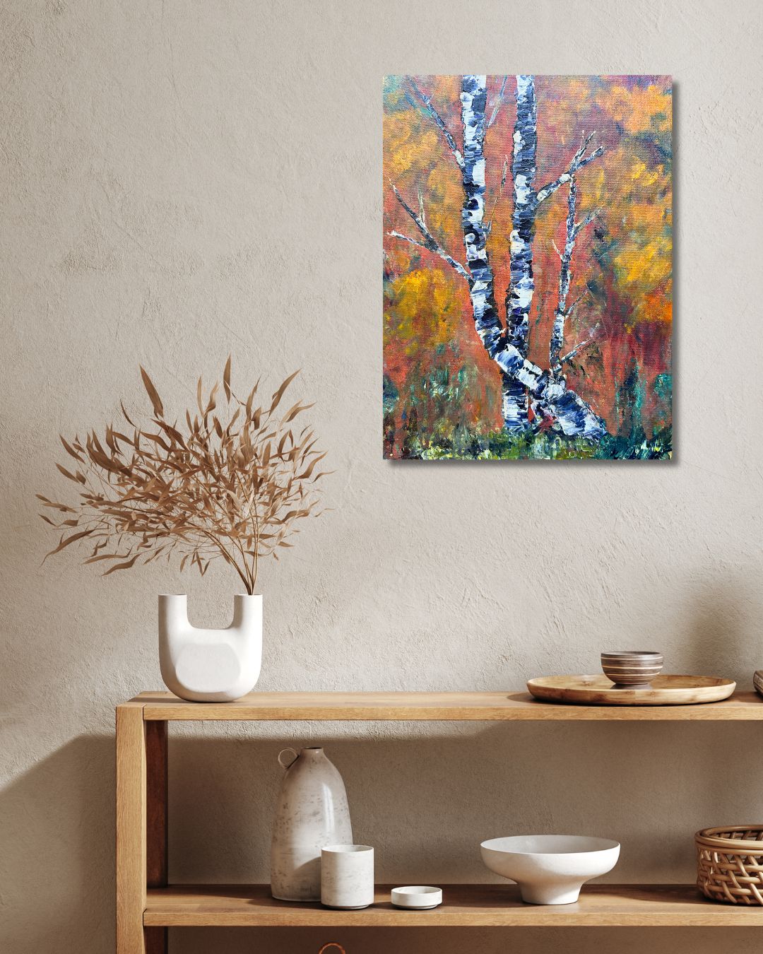 Original acrylic painting by Ottawa artist Mireille Laroche depicting trees with a fall background. Painting on a white wall over a shelf with a green plant. 