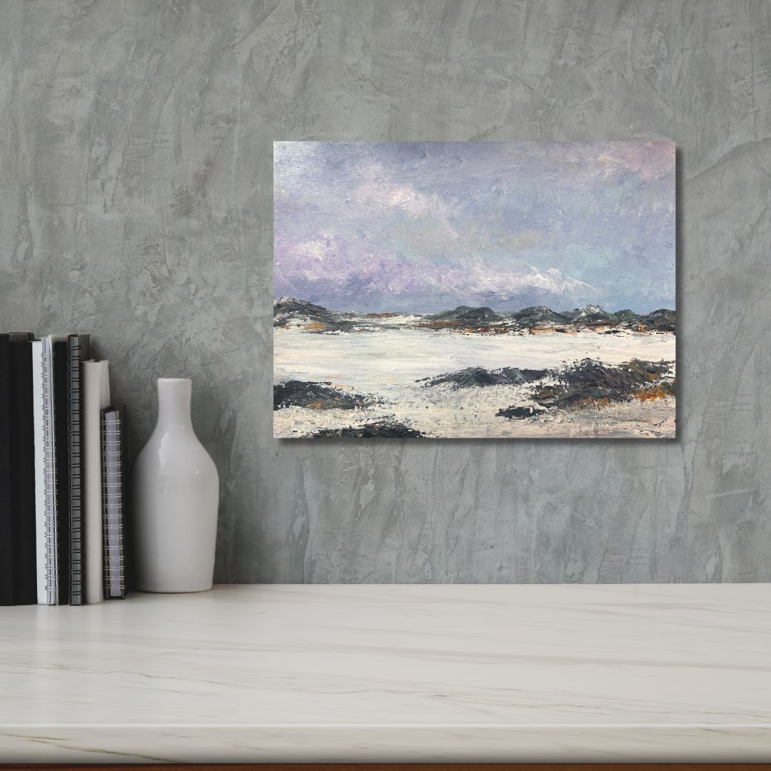 Abstract landscape painting on a gray wall with books and a vase below.